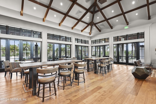 dining area featuring french doors, light hardwood / wood-style floors, and a high ceiling