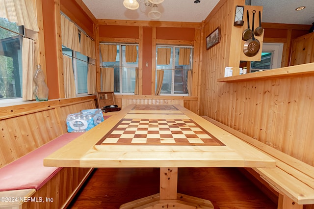 dining space with wood walls and a textured ceiling