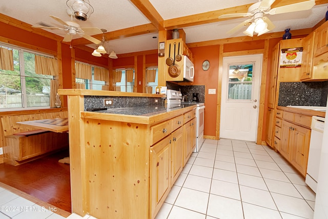 kitchen with light brown cabinets, white appliances, light tile patterned floors, and kitchen peninsula