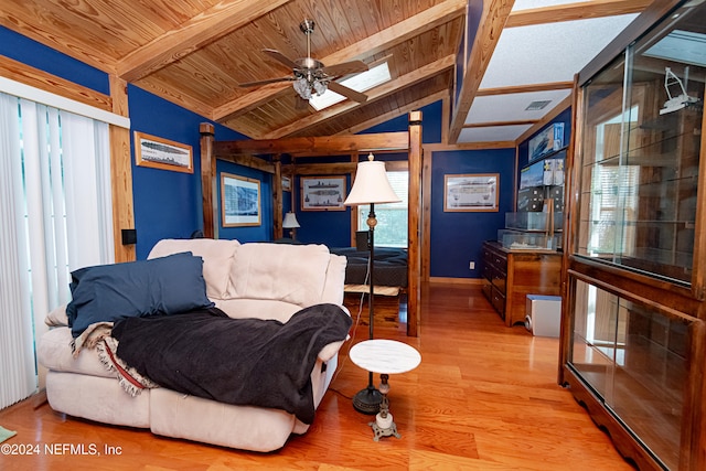 living room featuring wooden ceiling, light hardwood / wood-style floors, a healthy amount of sunlight, and lofted ceiling with skylight