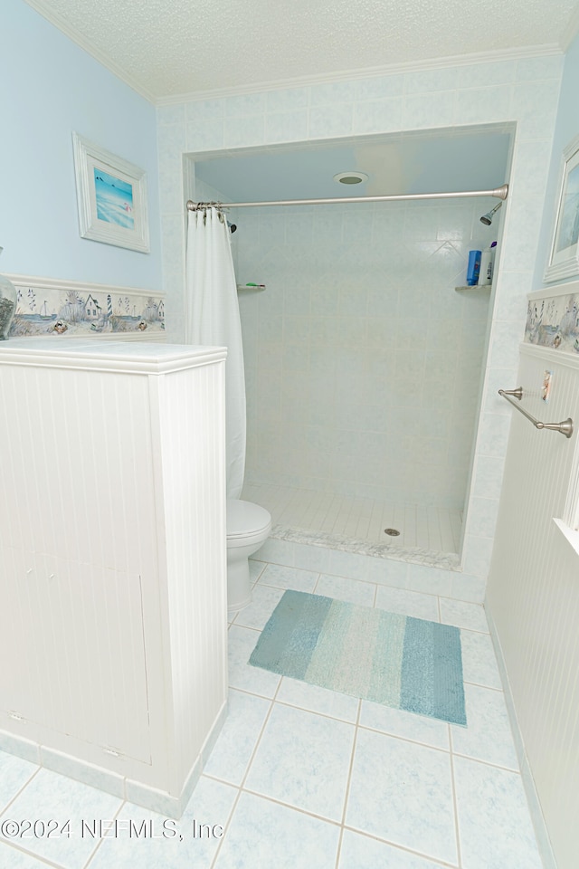 bathroom featuring toilet, a textured ceiling, tile patterned floors, and a shower with curtain