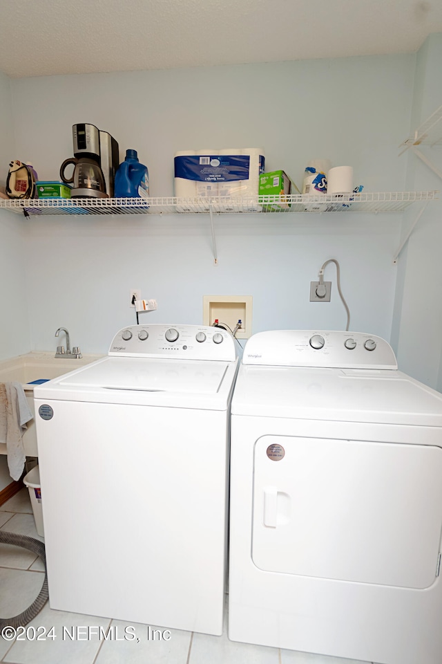 clothes washing area with tile patterned flooring and washing machine and clothes dryer