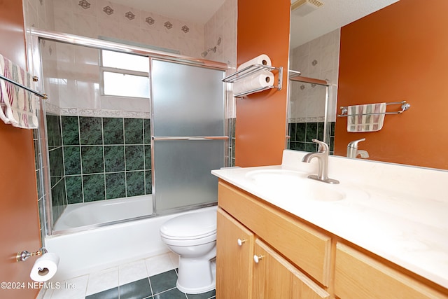 full bathroom featuring toilet, enclosed tub / shower combo, tile patterned floors, and vanity