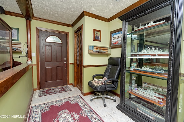 tiled foyer with a textured ceiling and crown molding