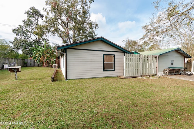 back of house with central air condition unit, a yard, and a patio area