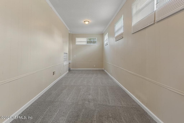 corridor with a textured ceiling, carpet flooring, and crown molding