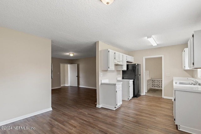 kitchen featuring sink, black fridge, dark hardwood / wood-style floors, white range, and white cabinets