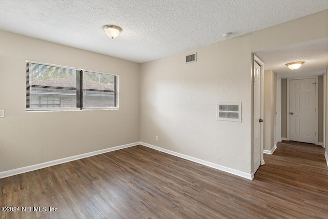 unfurnished room with dark wood-type flooring and a textured ceiling