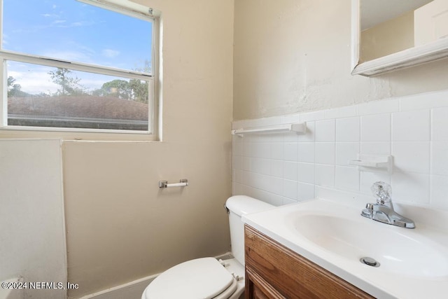 bathroom with tile walls, vanity, and toilet