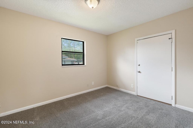 unfurnished room with a textured ceiling and carpet floors