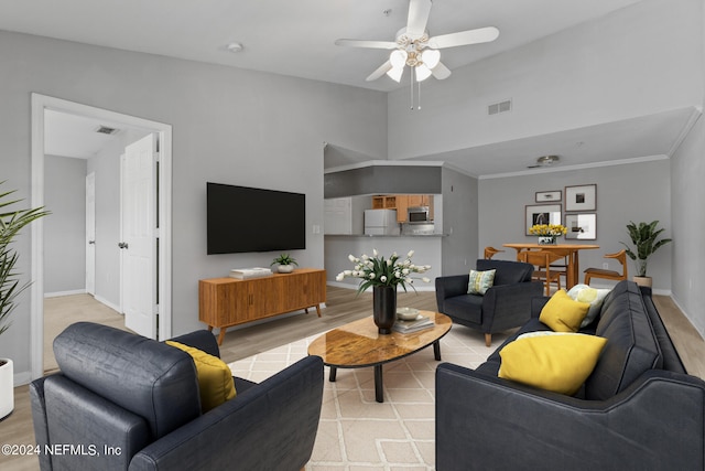 living room featuring ceiling fan, light hardwood / wood-style flooring, and crown molding