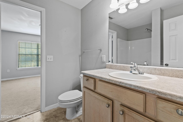 full bathroom featuring toilet, walk in shower, vanity, and baseboards