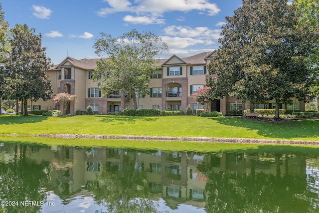 exterior space with a water view and a lawn