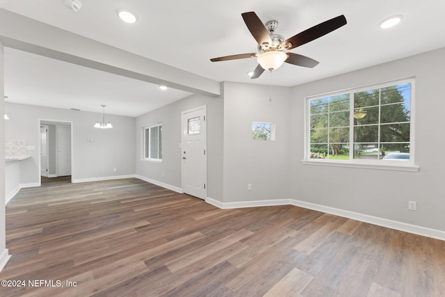 unfurnished room with wood-type flooring and ceiling fan with notable chandelier