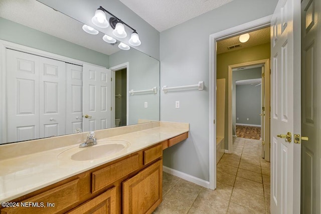 bathroom featuring vanity, tile patterned floors, and a textured ceiling