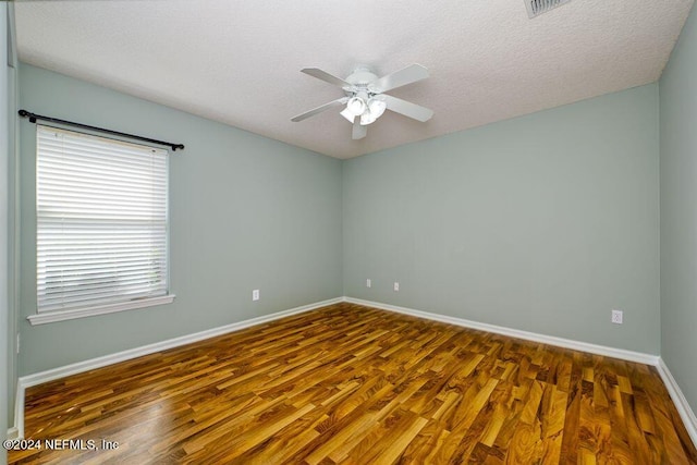 empty room featuring ceiling fan, dark hardwood / wood-style flooring, and a textured ceiling