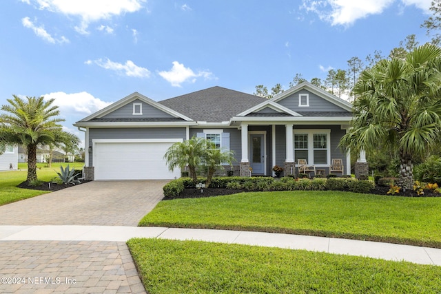 craftsman-style house featuring a front lawn, a garage, and covered porch