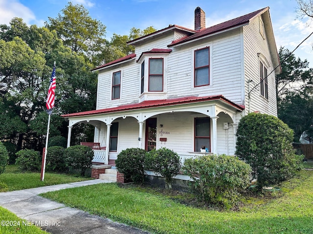 view of front of home with covered porch and a front yard