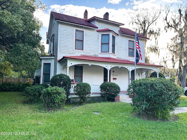 view of front of property featuring a front yard and covered porch