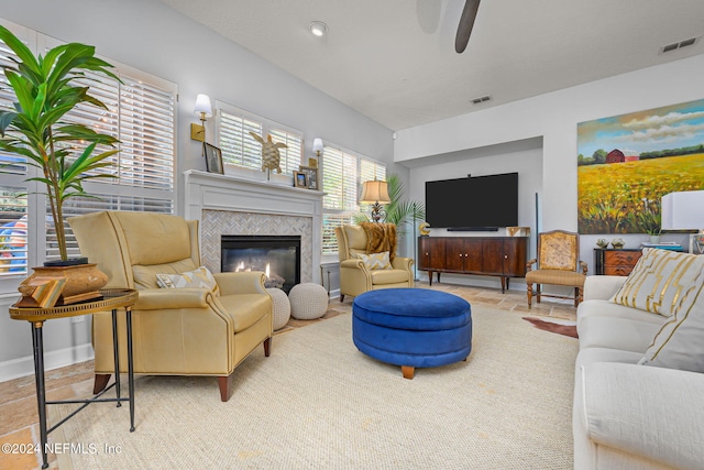 living room featuring a tile fireplace and ceiling fan