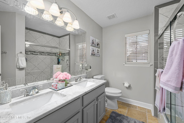 bathroom featuring a textured ceiling, vanity, toilet, and walk in shower