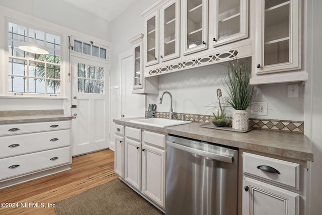 kitchen featuring light hardwood / wood-style flooring, stainless steel dishwasher, sink, and white cabinets