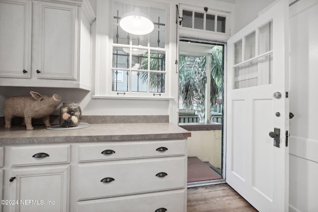 kitchen with white cabinets and light hardwood / wood-style flooring