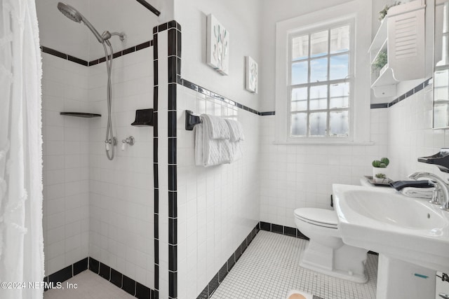 bathroom featuring toilet, tile walls, tile patterned flooring, and curtained shower