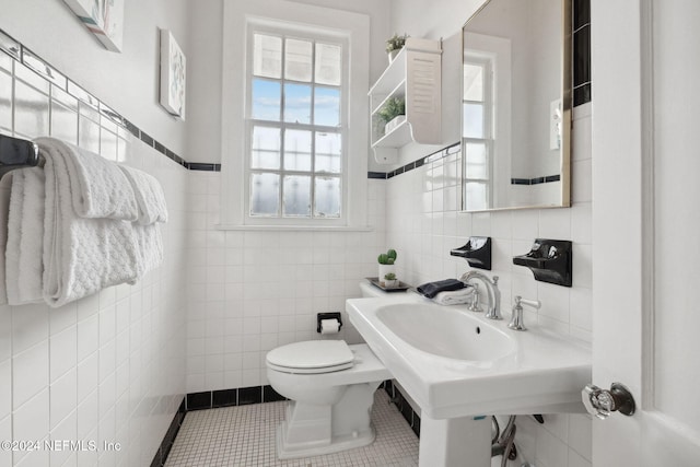 bathroom with tile walls, tile patterned flooring, and toilet