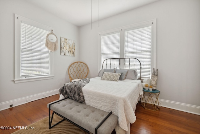 bedroom with dark hardwood / wood-style flooring and multiple windows