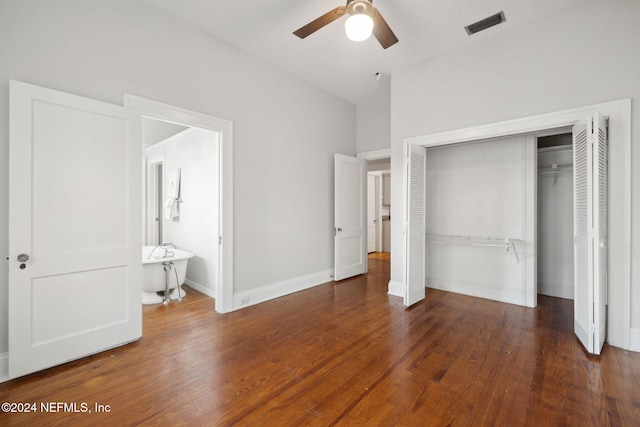 unfurnished bedroom featuring dark wood-type flooring, ceiling fan, ensuite bath, and a closet