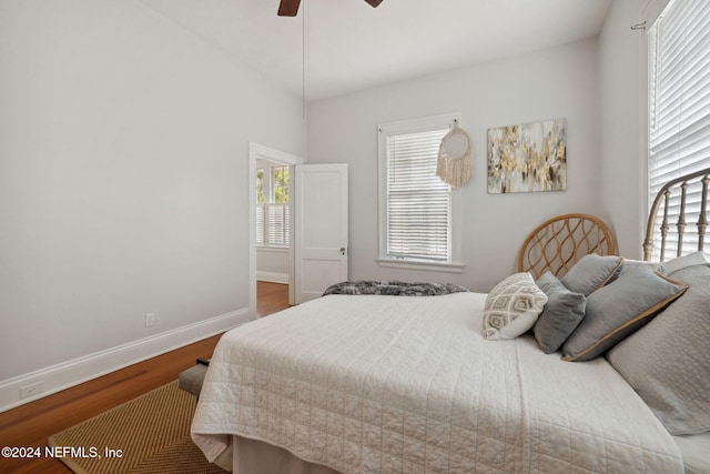 bedroom with hardwood / wood-style floors, ceiling fan, and vaulted ceiling