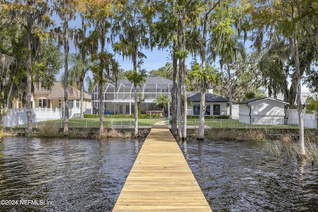 view of dock with a yard and a water view