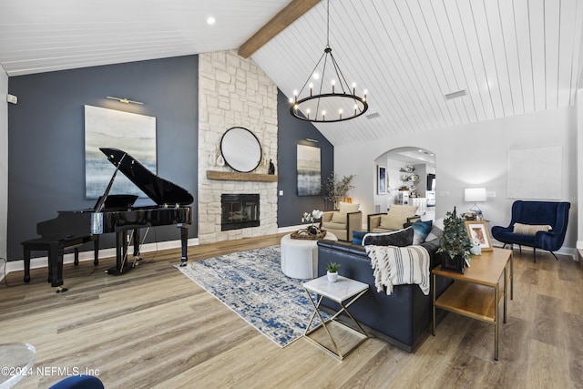 living room featuring a stone fireplace, hardwood / wood-style floors, beamed ceiling, and high vaulted ceiling