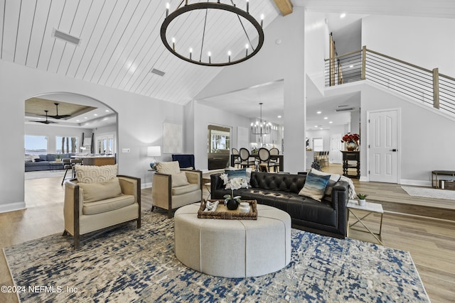 living room featuring wood-type flooring, ceiling fan with notable chandelier, high vaulted ceiling, and wooden ceiling