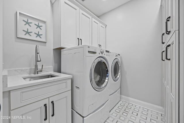 laundry area featuring cabinets, washing machine and clothes dryer, and sink