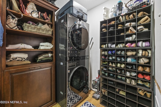 washroom with hardwood / wood-style floors, a textured ceiling, and stacked washing maching and dryer