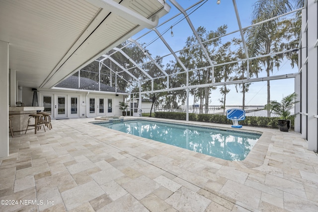 view of pool featuring an outdoor bar, french doors, a patio, and glass enclosure