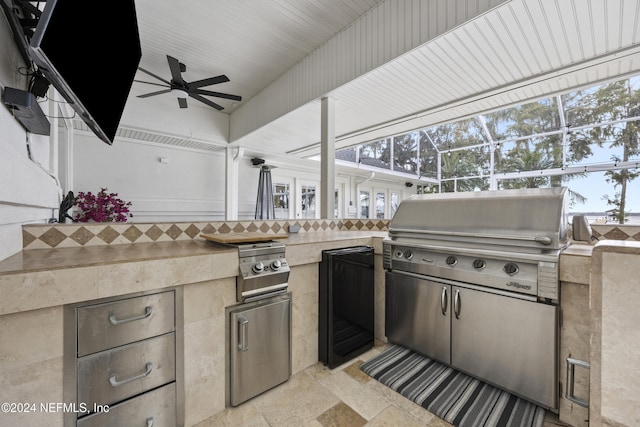 view of patio / terrace featuring an outdoor kitchen, glass enclosure, ceiling fan, and a grill