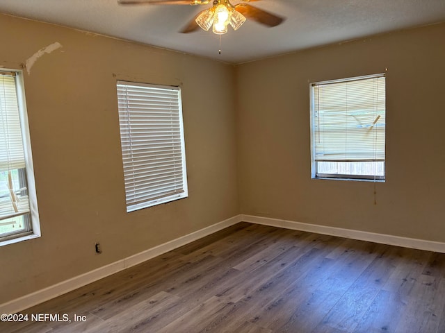 unfurnished room with ceiling fan, plenty of natural light, and wood-type flooring