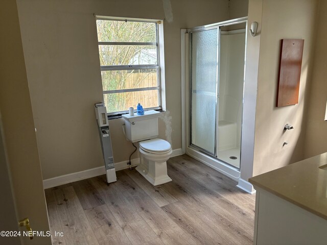 bathroom with hardwood / wood-style flooring, toilet, an enclosed shower, and vanity