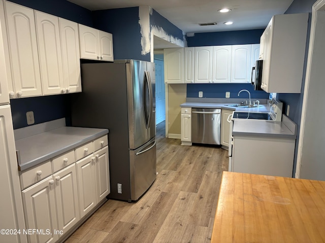 kitchen featuring light hardwood / wood-style floors, white cabinetry, sink, and appliances with stainless steel finishes