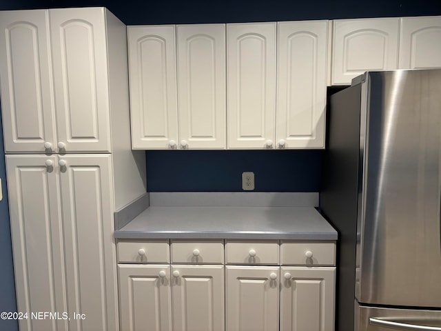 kitchen featuring white cabinetry and stainless steel refrigerator