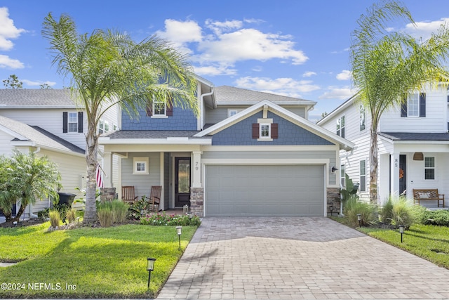 view of front facade featuring a front yard, a garage, and covered porch