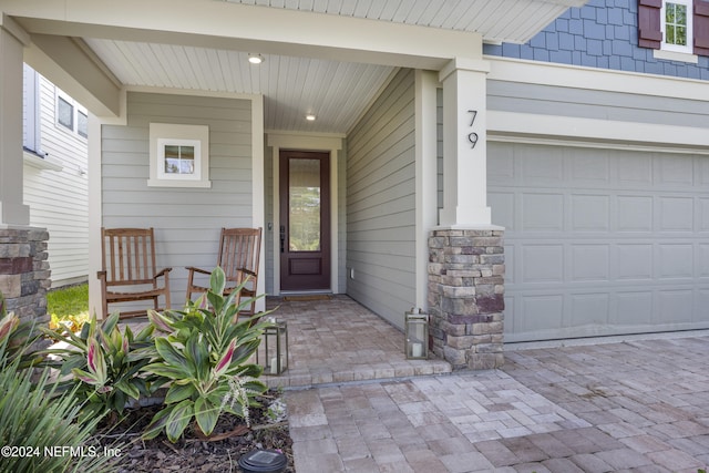 property entrance with covered porch and a garage