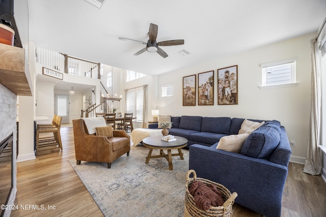 living room featuring hardwood / wood-style floors, ceiling fan with notable chandelier, and a wealth of natural light