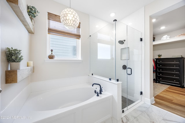 bathroom featuring separate shower and tub and hardwood / wood-style floors