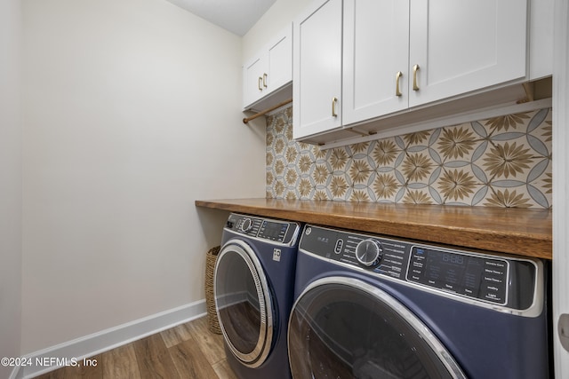 laundry area with hardwood / wood-style floors, cabinets, and independent washer and dryer