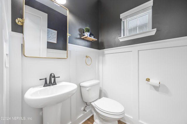 bathroom featuring toilet, wood-type flooring, and sink