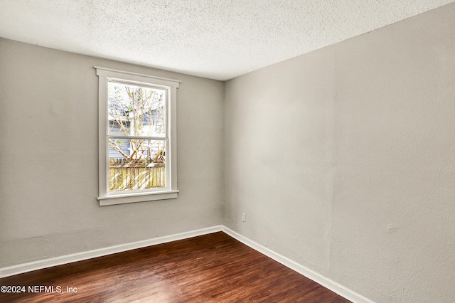 unfurnished room with hardwood / wood-style floors and a textured ceiling